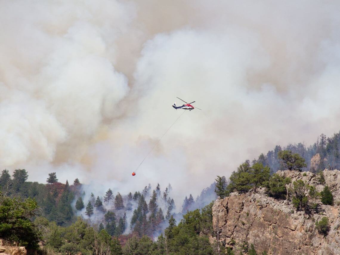 Helicopter dropping water on Grizzly Creek Fire in Glenwood Canyon