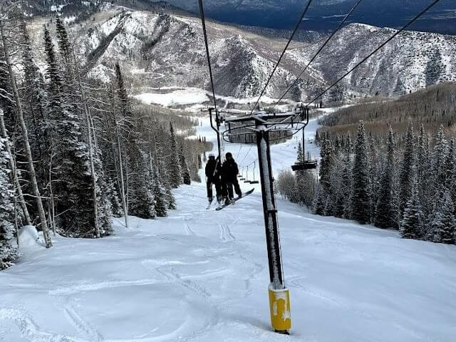 A ski lift carries people over a ski run at Sunlight Mountain Resort