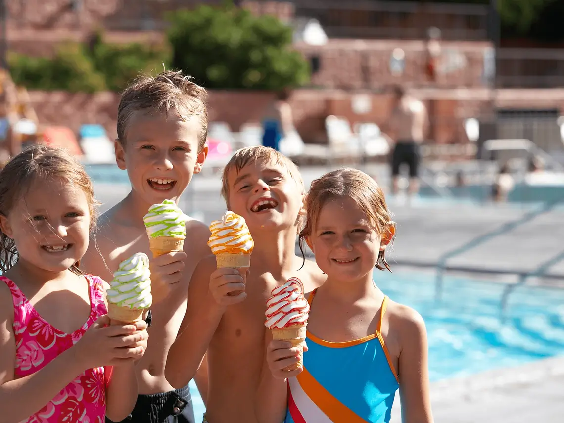 Four children in swimsuits holding ice cream cones at Glenwood Hot Springs pool
