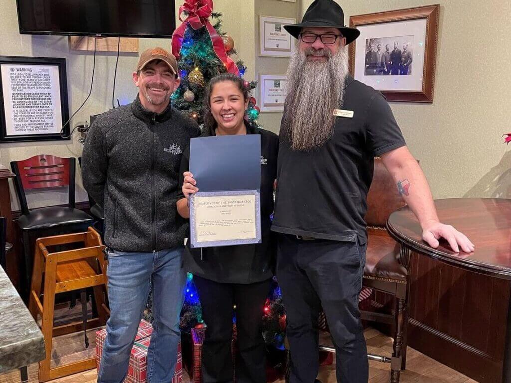 Sarah Scott holds Employee of the Month award at Hotel Colorado