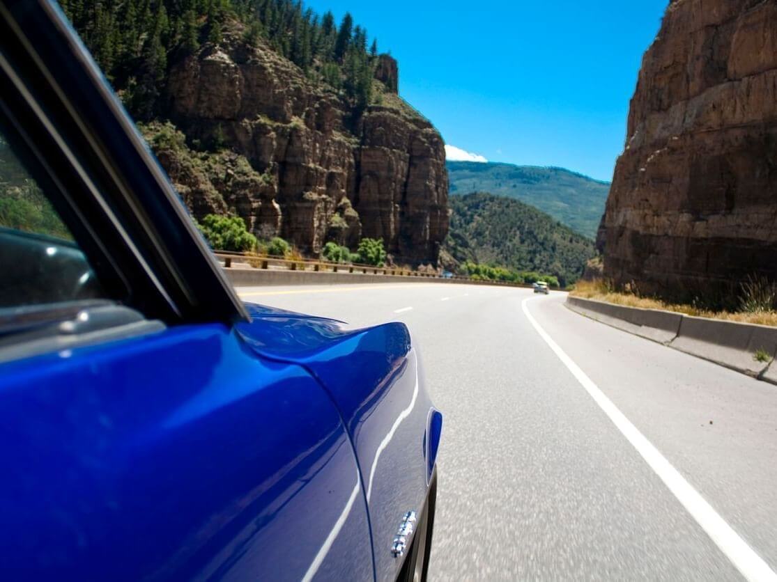 Blue Cadillac driving through Glenwood Canyon