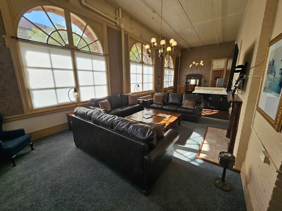 The Devereux Suite in Hotel Colorado features a large lounge area with arched windows