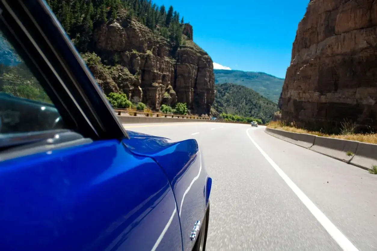 Blue Cadillac driving through Glenwood Canyon