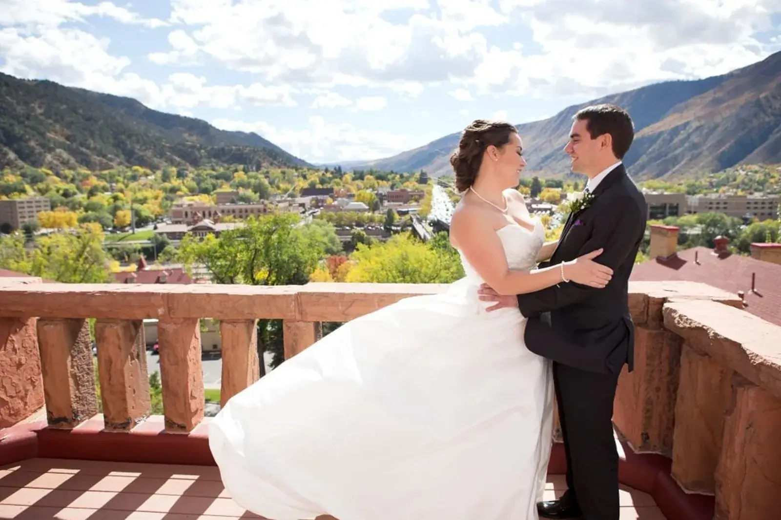 Bride and groom holding each other on a balcony at Hotel Colorado in Glenwood Springs