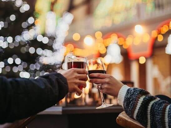 Two people clink glasses during the holidays in the courtyard of Hotel Colorado