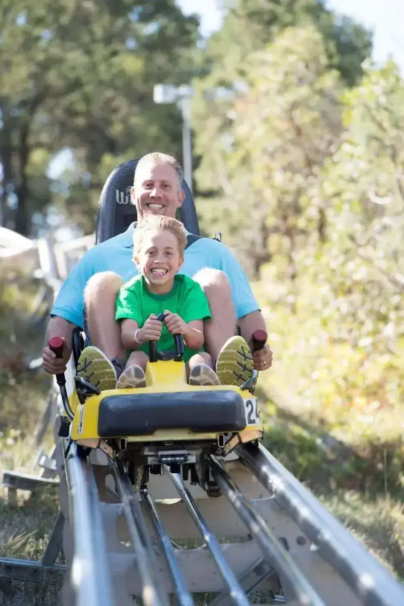 A man and a child enjoying the Alpine Coaster ride at Glenwood Caverns Adventure Park