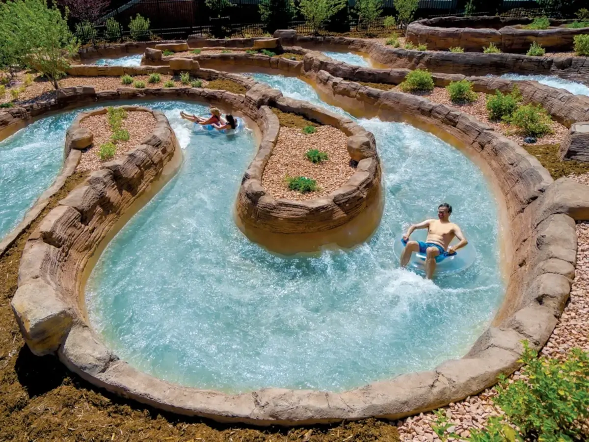 Adults meandering down Shoshone Chutes on inflatable tubes at Glenwood Hot Springs Splash Zone