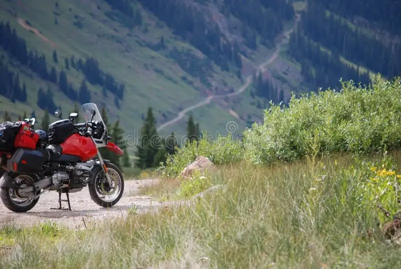 A red touring motorcycle parked along scenic highway in Colorado