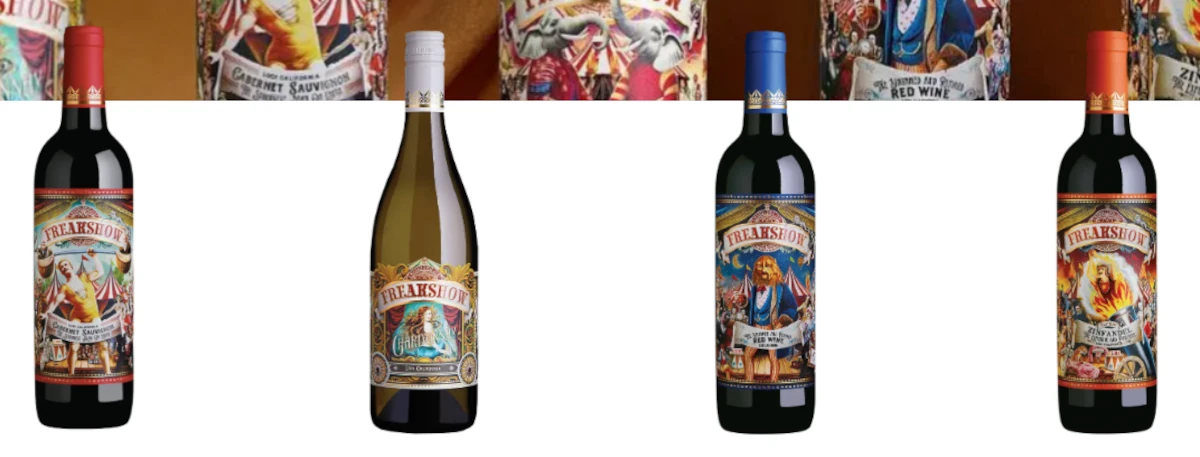 Five bottles of Freakshow wine with illustrated, colorful circus-themed labels are displayed in a row against a white background—perfect for adding flair to your spring break celebrations. Four bottles are red wine and one is white wine.